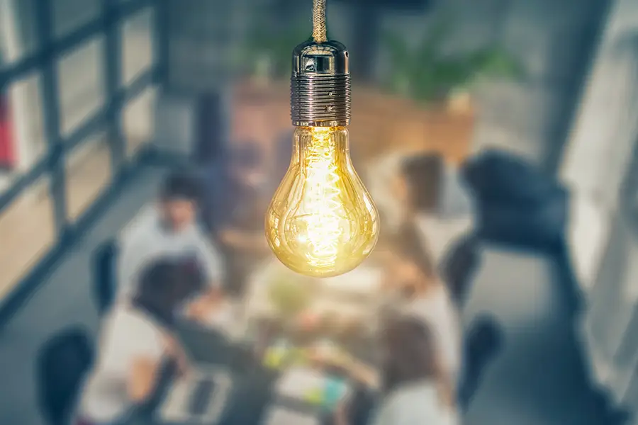 focused lightbulb above blurred conference table